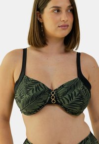 Haut de bikini à armatures en vert foncé avec un motif de feuilles de palmier, des détails noirs et un accent circulaire doré au centre. Texture douce.
