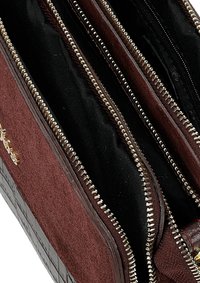 Portafoglio bordeaux con zip, dotato di tre scomparti, caratterizzato da un esterno testurizzato, foderato in nero e con dettagli in oro.