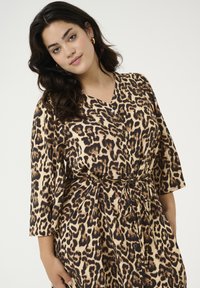 Robe à boutons imprimée léopard avec un col en V, des manches trois-quarts, une taille cintrée et un tissu doux avec une texture lisse.