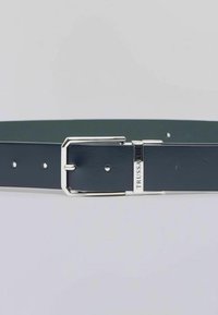 Granatowy skórzany pasek z prostokątną srebrną klamrą i srebrnym akcentem w postaci logo, z wieloma otworami do regulacji na pasku.