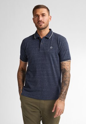 Camiseta polo azul marino con cuello en contraste y textura horizontal, con un pequeño logo en el pecho. Diseñada con mangas cortas.