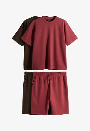 Dos conjuntos de ropa informal; una camiseta y pantalones cortos burdeos, y una camiseta y pantalones cortos marrón oscuro, ambos con cintura elástica y bolsillos.