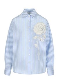 Koszula na guziki w pionowe paski w jasnoniebieskim i białym kolorze z długimi rękawami oraz dużym białym kwiatowym wzorem z koronki po lewej stronie.