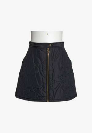 Mini-jupe matelassée noire avec fermeture éclair dorée à l'avant et pression, ornée de motifs floraux et de logo en relief.