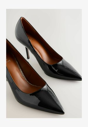 Schwarze Lackleder-Pumps mit einer spitzen Zehenform, ausgestattet mit einem schlanken Stiletto-Absatz und einer glatten braunen Innenauskleidung.