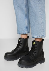 Buffalo ASPHA - Botas de tornozelo com plataforma - black/transparent