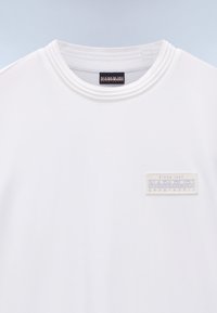 T-shirt bianca a maniche corte in cotone liscio. Presenta una scollatura a girocollo a costine e un'etichetta tessuta testurizzata sul petto a sinistra.