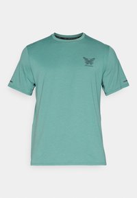 Teal lyhythihainen t-paita, joka on valmistettu teksturoidusta kankaasta. Siinä on pieni musta grafiikka ja huomaamattomat yksityiskohdat hihoissa. Rentoa mallia.