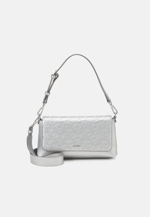 Silver shoulder bag with monogram pattern on flap, adjustable strap, and smooth leather body.