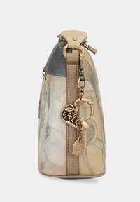 Borsa a mano floreale beige con corpo testurizzato, accenti metallici e un charm decorativo. Presenta una forma strutturata e una parte superiore metallica.