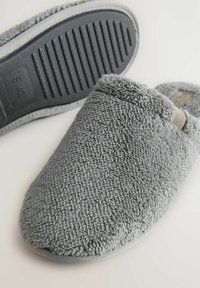 Soft gray fuzzy slippers with ribbed black rubber sole, size 42, designed for indoor comfort and warmth.