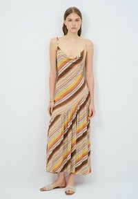 Maxikleid mit dünnen Trägern, mit einem Cowl-Ausschnitt, im mehrfarbigen Streifenmuster aus Gelb, Braun und Orange. Fließender Stoff, geraffte Taille.