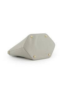 Sac à main en cuir gris clair avec un socle octogonal, présentant des clous et des coutures dorés. Texture lisse et design minimaliste.