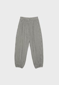 Pantalon ample à petits carreaux noirs et blancs avec taille élastique et poignets élastiques froncés, présenté sur un fond uni.