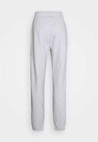 Pantalones deportivos gris claro con cintura elástica y puños elásticos, vistos desde atrás sobre un fondo blanco.