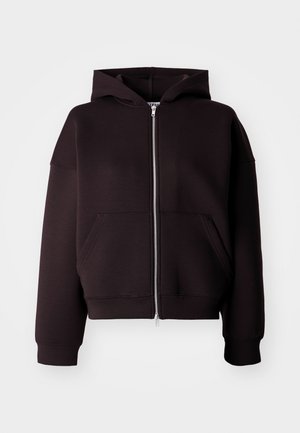 Sweat à capuche noir à fermeture éclair, fabriqué en tissu doux. Il présente une coupe courte, des poches spacieuses et une grande capuche. Texture lisse avec des poignets côtelés.