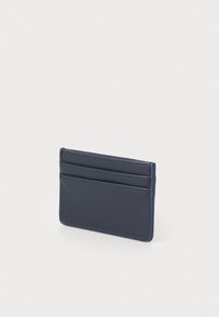 Navy lærkortholder med fire lommer, slank design, glat tekstur og synlige sting. Har en minimalistisk rektangulær form.