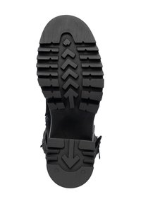 Suela de bota de goma negra con surcos profundos. Presenta patrones geométricos y un tacón reforzado. Sólida y texturizada para mejorar el agarre.