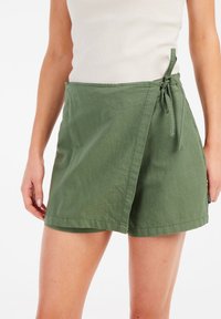 Olijfgroene wikkelrok van lichtgewicht stof, met een zijsluiting en een comfortabele pasvorm met een gladde textuur.