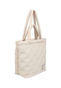 Sac fourre-tout beige clair en tissu matelassé, avec deux poignées rembourrées, un accent de panneau latéral et une petite étiquette de marque en bas.