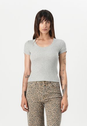 Grå kortermet bomullst-skjorte med rund hals, tettsittende design, kombinert med høyt midje leopardmønstret jeans med knappelukking.
