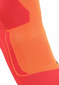 Calze sportive in un brillante arancione e rosso, caratterizzate da una texture a coste e zone rinforzate per una maggiore durata. I motivi distintivi migliorano la presa.