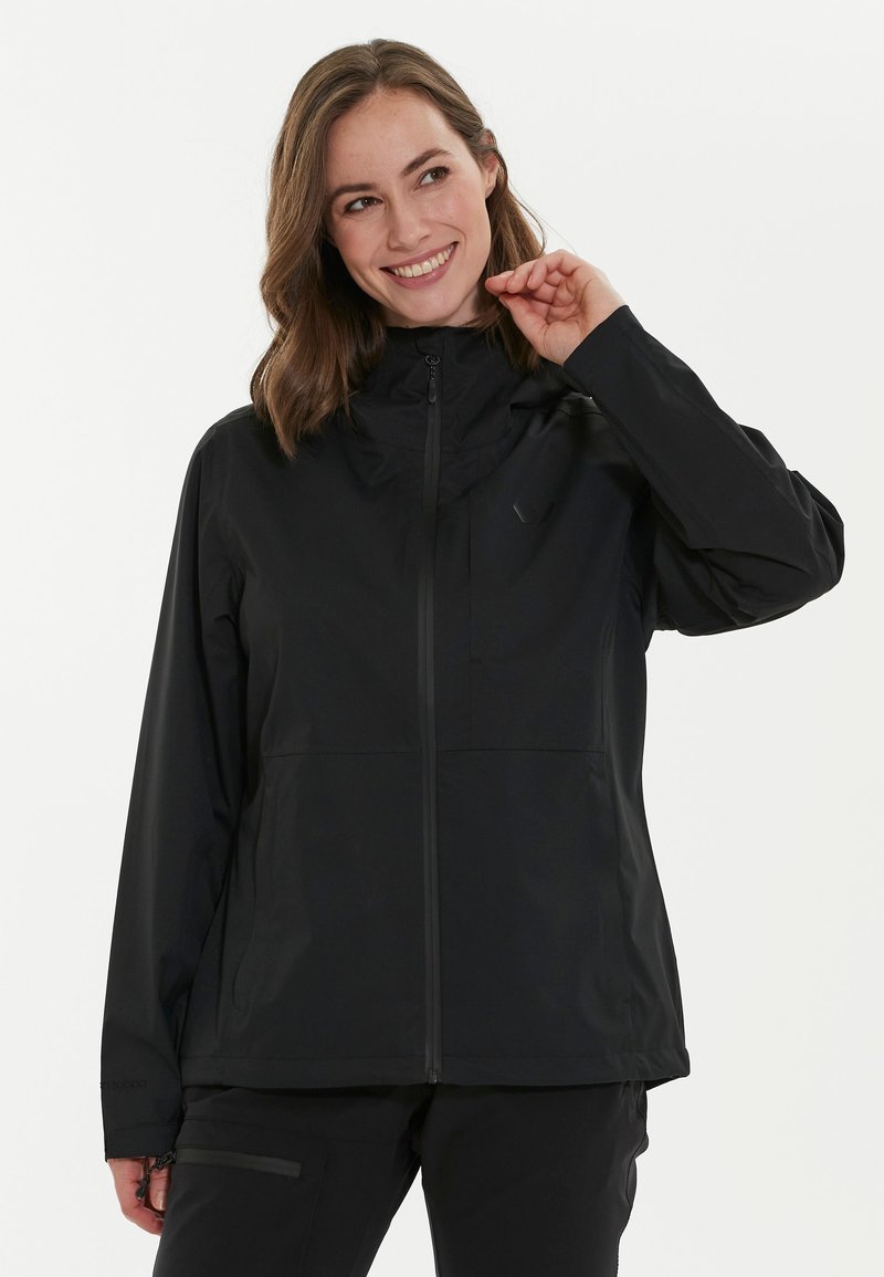 Veste waterproof noire avec un col haut, fermeture éclair à l'avant et poches latérales. Texture lisse avec un design minimaliste.