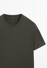 Dunkel olivgrünes T-Shirt mit kurzen Ärmeln aus weicher Baumwolle. Es verfügt über einen Rundhalsausschnitt und ein schlichtes, sauberes Design ohne sichtbare Muster oder Akzente.