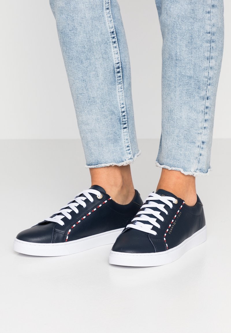 Sneakers in pelle blu navy con lacci bianchi, cuciture a contrasto e suole in gomma testurizzata, con un logo sul lato.