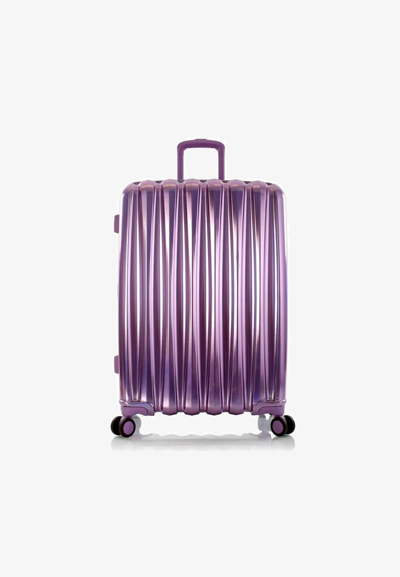 Valise rigide en violet brillant, avec un design strié, une poignée supérieure et quatre roues multidirectionnelles pour une mobilité facile.
