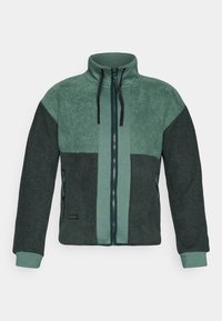 Green and dark green fleece jacket with full front zipper, high collar, drawstrings, and zippered side pockets.