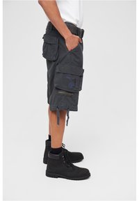 Gray cargo shorts with multiple pockets, a zippered side pocket, and side ties at the hem, paired with black lace-up boots.
