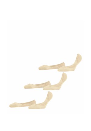 Trois paires de chaussettes invisibles beiges, deux paires à plat et une paire partiellement dressée, exposées sur un fond blanc uni.