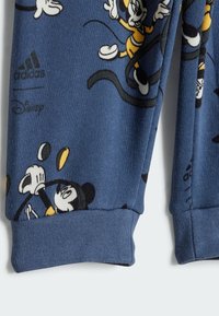 Pantaloni joggers in cotone blu con un motivo di personaggi Disney, tra cui Topolino, dotati di polsini a coste e dettagli con logo.