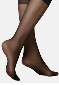 Durchsichtige braune Strumpfhosen mit glatter Textur, die ein mattes Finish und ein blickdichtes Bündchen oben aufweisen. Entworfen, um eng an den Beinen zu sitzen.