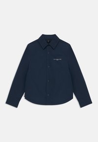Marineblå knapp-up skjorte i lett stoff. Har en klassisk krage, brystlomme med logo, og buet kant. Langermet.
