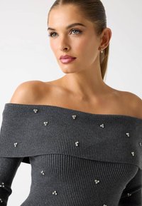 Szary sweter z odkrytymi ramionami, prążkowany, z kryształowymi zdobieniami, o luźnym kroju i ciekawej fakturze.