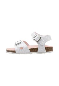 Sandalias blancas con correas texturizadas, dos hebillas ajustables de plata, plantilla de corcho y suela de goma blanca. Diseño plano para mayor comodidad.