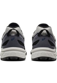 Grå och svarta löparskor visade från baksidan, med tjocka vita sulor och svarta häldragflikar.