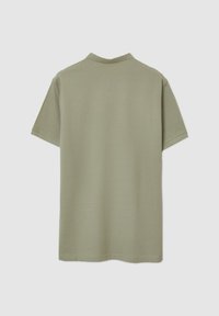 T-shirt a maniche corte in un verde oliva spento, realizzato in tessuto leggero e morbido con colletto a girocollo e design pulito e semplice.