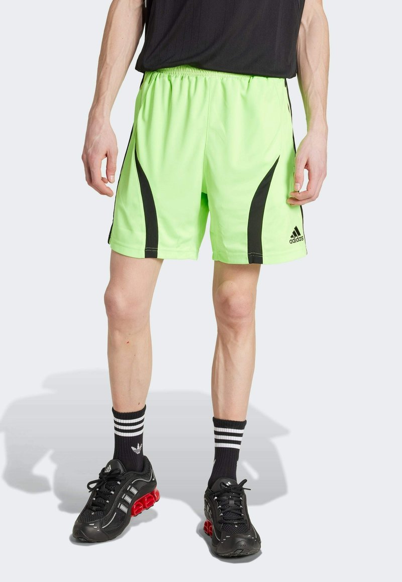 Neon green athletic shorts with black side accents and a lightweight design. Paired with black shoes and striped socks for a sporty look.