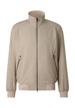 Beige lynlåstrøje med opretstående krave, lange ærmer, lynlåslommer samt elastiske manchetter og kant.