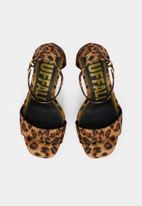 Sandalias con estampado de leopardo, suela plana, tiras en el tobillo y una banda ancha en los dedos. Tienen herrajes dorados y forro interior negro.