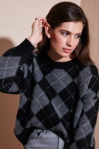 Maglione a motivo argyle nero e grigio con scollatura rotonda, maniche lunghe e vestibilità ampia. Texture morbida con delicati accenti di cuciture bianche.