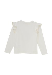 Långärmad vit topp tillverkad av mjuk bomull, med rynkade axelaccenter med en diskret guldtrim. Bakifrån visar den en sömlös design.