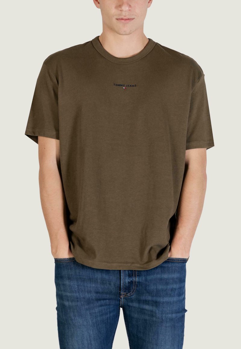T-shirt in cotone verde oliva con vestibilità comoda, maniche corte e scollo rotondo. Piccolo logo "TOMMY JEANS" ricamato sul petto.
