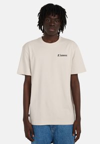 Μπεζ βαμβακερό T-shirt με κοντά μανίκια και στρογγυλή λαιμόκοψη, με μικρό μαύρο λογότυπο "E.lement" στο αριστερό στήθος. Casual εφαρμογή.