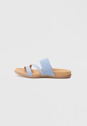 Sandalo con suola azzurra chiara con due ampie fasce in tessuto e suola marrone strutturata, con design piatto e a punta aperta.