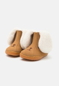 Brune fleece tøfler med hvite kunstpelsører, sydd detaljer og gummisåle. Har en enkel hundefjes-kontur foran.