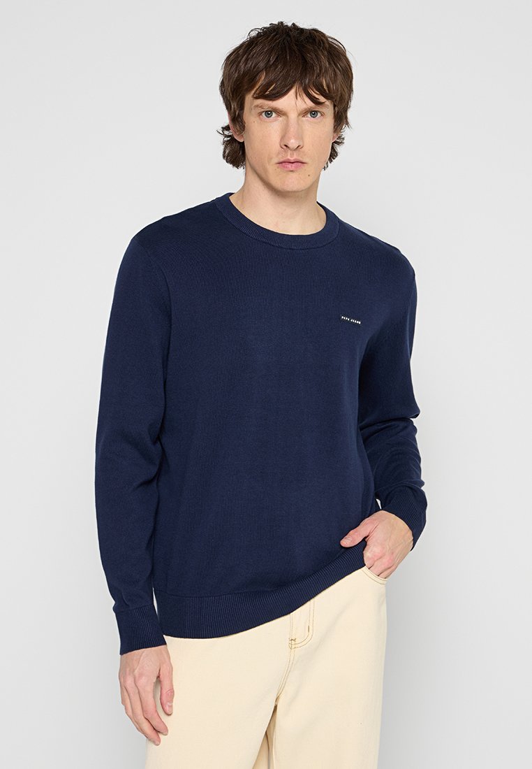 Maglione lavorato a maglia blu navy con scollatura a girocollo, polsini e orlo a coste, dotato di un piccolo logo sul petto, realizzato in un tessuto morbido.